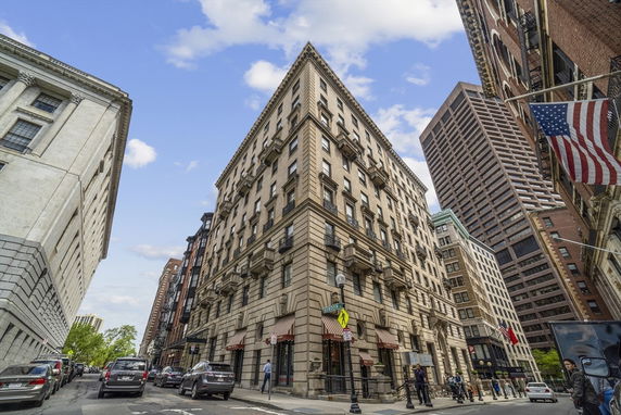 Front view of a multi-story urban building on a city street corner.