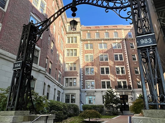 Front view of a multi-story brick building with decorative iron entrance.