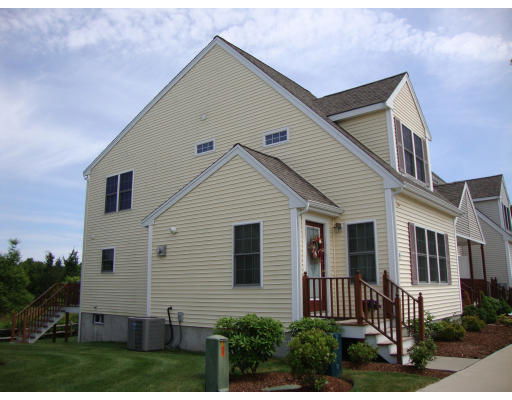 Front view of a two-story house with beige siding and multiple windows.