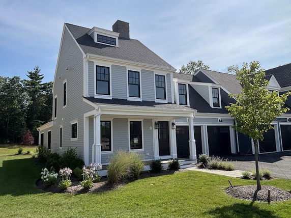 Front view of a two-story house with a gray facade and garage.