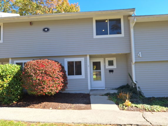 Front view of a two-story house with gray siding and several windows.