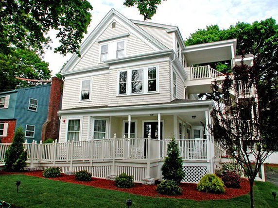 Front view of a multi-story house with a porch.