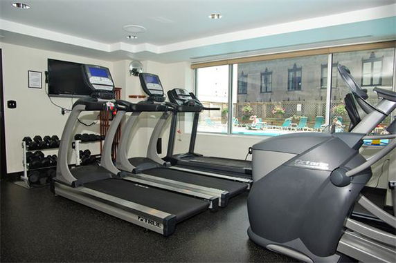 Room with treadmills and exercise equipment, featuring a window view of an outdoor area.