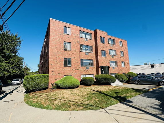 Front view of a four-story brick apartment building.