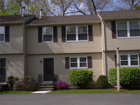 Front view of a townhouse with two stories and tan siding.