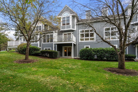 Front view of a two-story building with balconies and large windows.