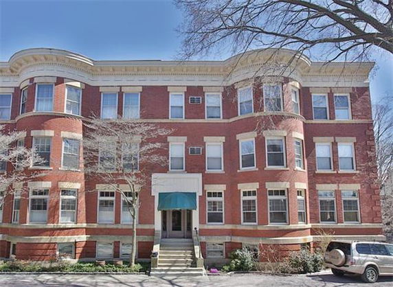 Front view of a three-story brick building with numerous windows and a central entrance.
