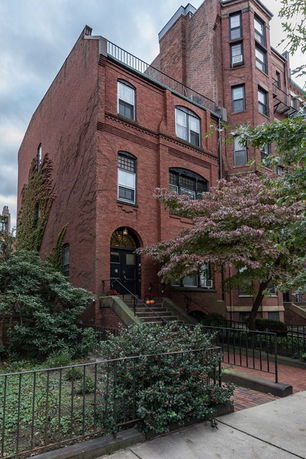 Front view of a multi-story brick building with an arched entrance.