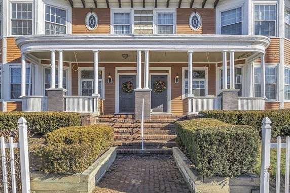 Front view of a house with multiple windows and a covered porch.
