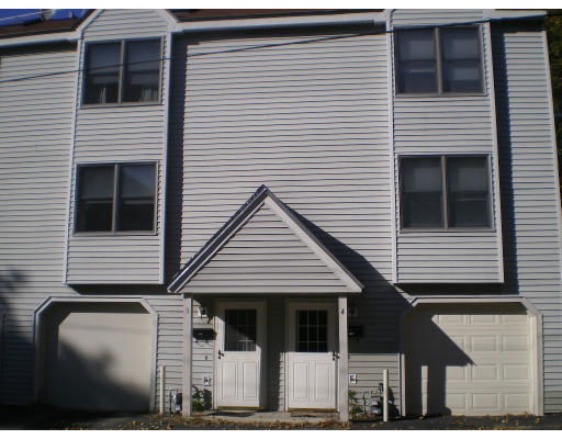 Front view of a multi-story house with two entrances and two garages.