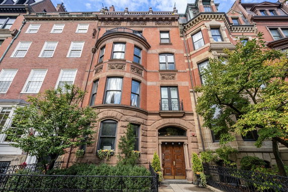 Front view of a multi-story brick building with decorative stonework around the windows and entrance.