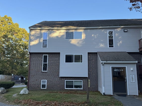 Front view of a multi-story residential building with brick and siding exterior.