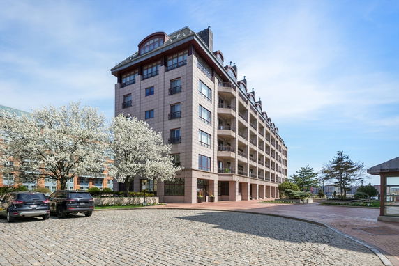 Front view of a multi-story residential building with balconies and decorative windows.