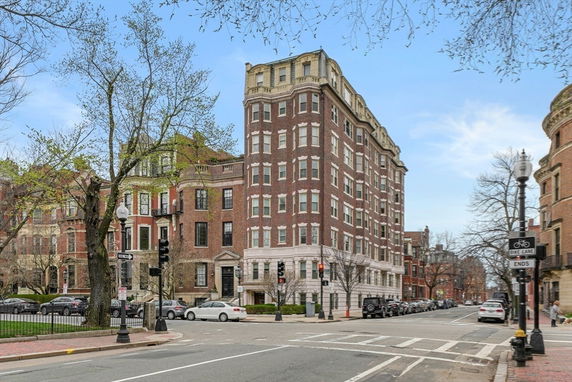Front view of a multi-story brick building on a city street corner.