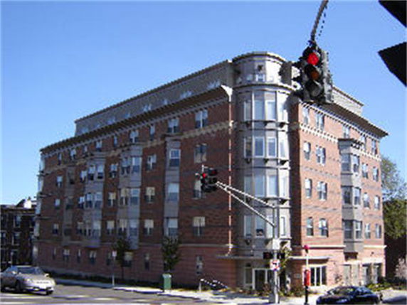 Front view of a multi-story apartment building on a corner lot.