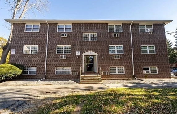 Front view of a three-story brick apartment building.