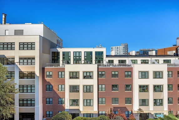 Front view of a multi-story building with a mix of brick and beige facade.