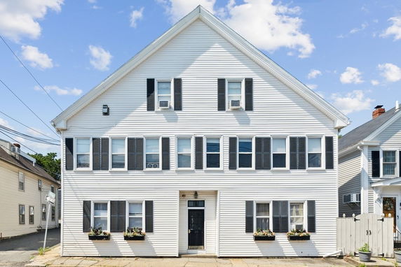 Front view of a two-story house with a gable roof and white exterior.