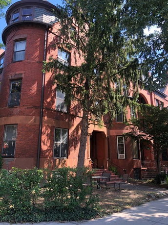 Front view of a multi-story brick building with arched windows.