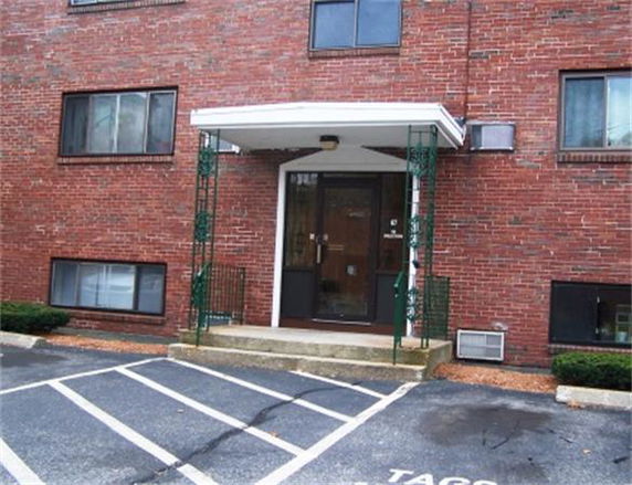 Front view of a brick apartment building entrance with a covered doorway.