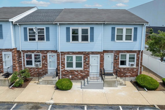 Front view of a two-story townhouse with blue siding and brick facade.