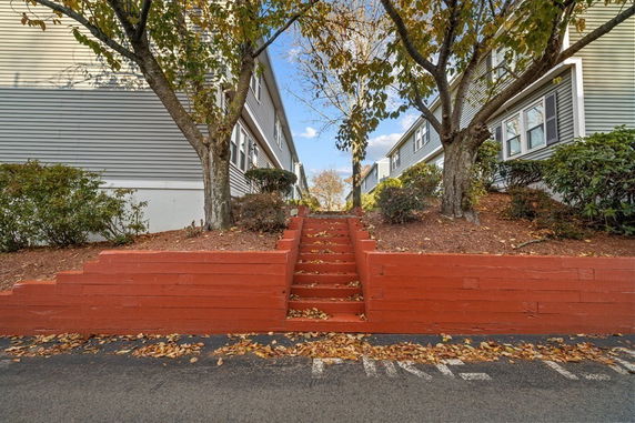 Front view of a split-level apartment building with stairs leading up between two buildings.
