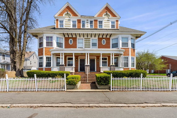 Front view of a two-story house with a symmetrical design and dual entrances.