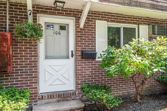 Front view of a house with a white door and brick exterior.