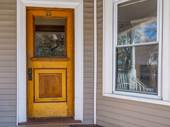 Front view of a building with a wooden door and window.