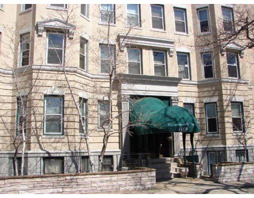 Front view of a multi-story building with a green awning entrance.