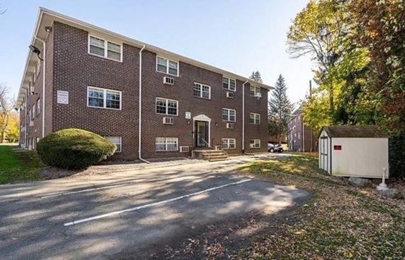 Front view of a three-story brick apartment building.