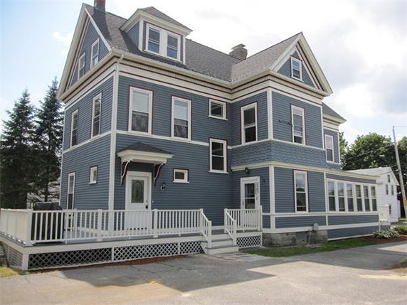 Front view of a large two-story house with blue siding and white trim.