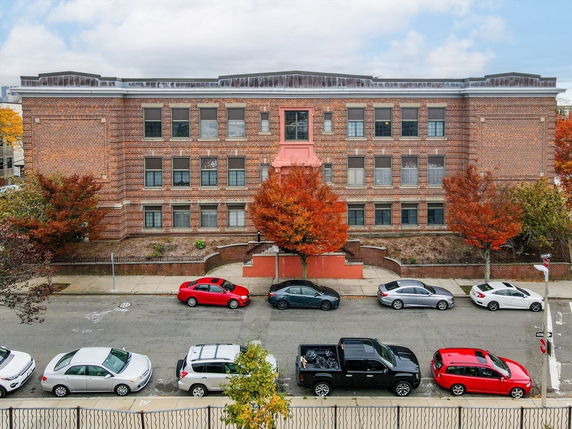 Front view of a three-story brick building with multiple windows and a central entrance.