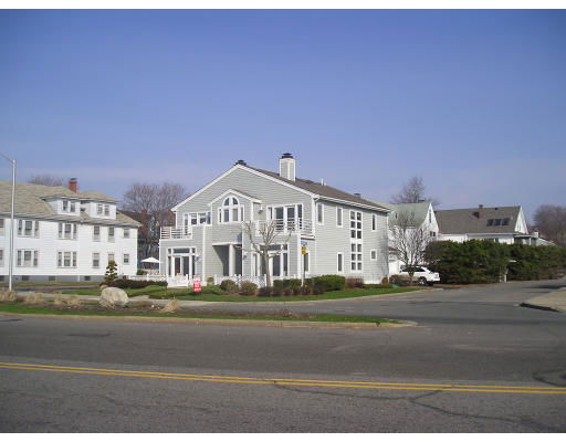 Front view of a two-story house with gray siding and a central chimney.