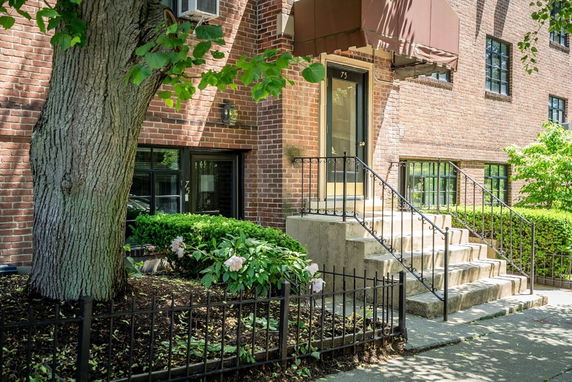 Front view of a brick building with stairs leading to the entrance.