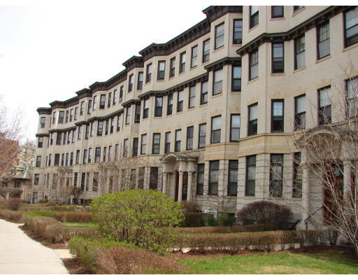 Front view of a multi-story residential building with bay windows.