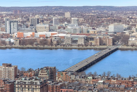 Panoramic view of a cityscape with a river and bridge.