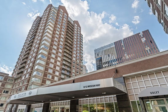 Front view of a tall residential building with multiple floors and balconies.