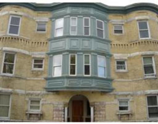 Front view of a multi-story residential building with a prominent bay window feature.