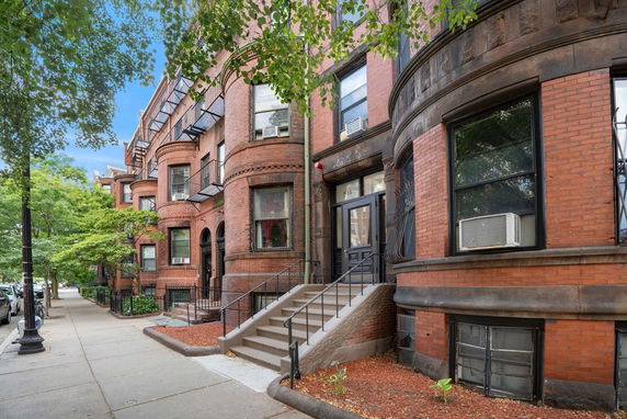 Front view of a brick row house with distinct architectural details.