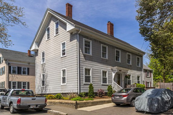 Front view of a two-story house with multiple windows and a chimney.