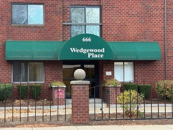 Front view of a building with a green awning labeled 'Wedgewood Place'.