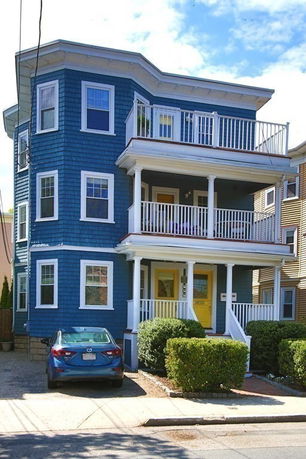 Front view of a three-story blue house with balconies.