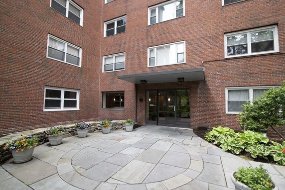 Front view of a multi-story brick building entrance with glass doors.