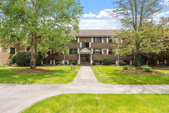 Front view of a two-story brick building with a gabled entrance.