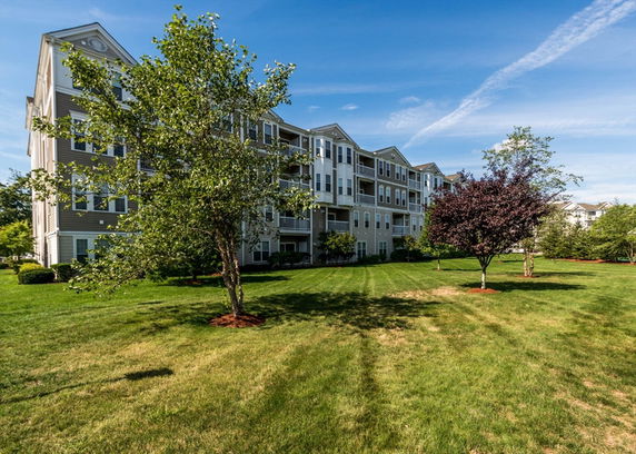 Front view of a multi-story apartment building with several balconies.