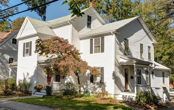 Front view of a two-story house with white siding and multiple gables.
