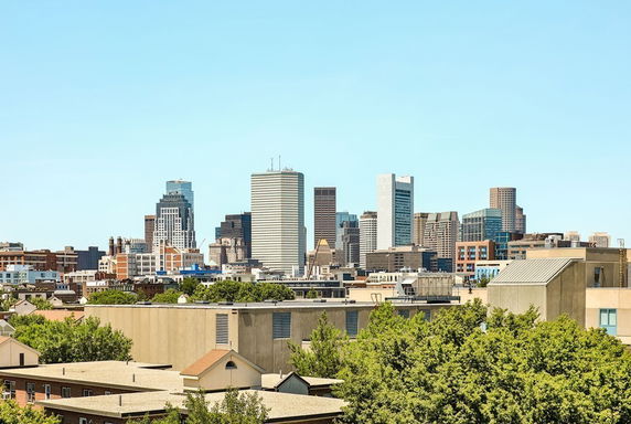 Panoramic view of a city skyline with tall buildings and clear sky.