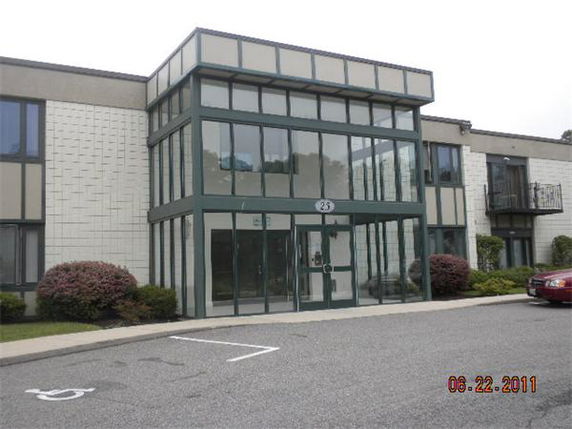 Front view of a two-story building with large glass windows and entrance.