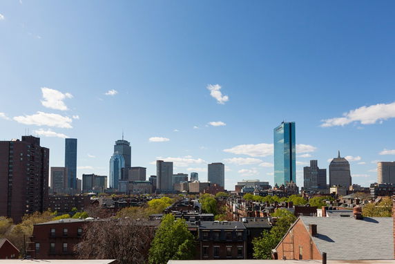 Panoramic view of a city skyline with multiple high-rise buildings against a clear blue sky.
